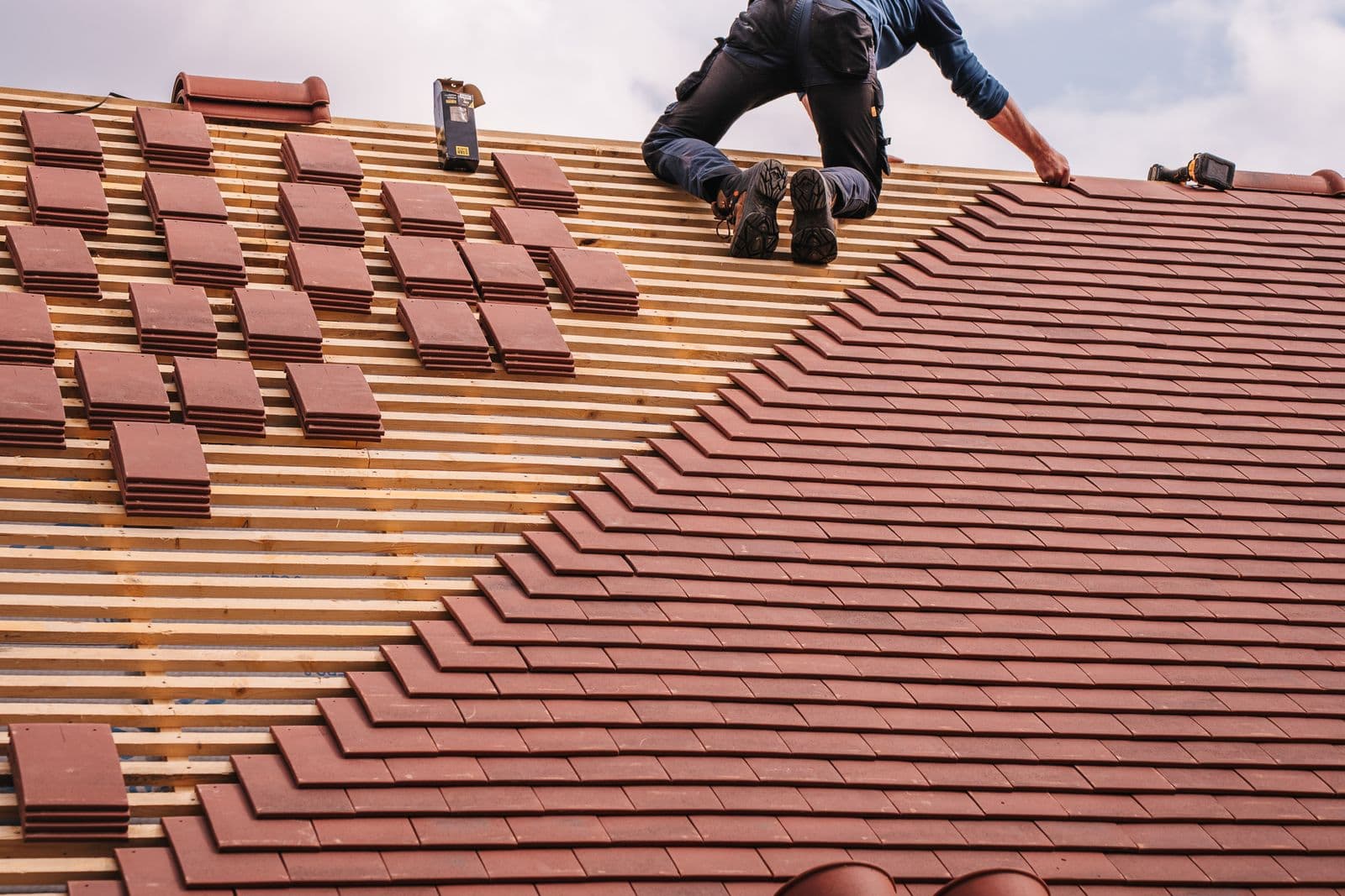A Summit roofer laying new clay roof tiles